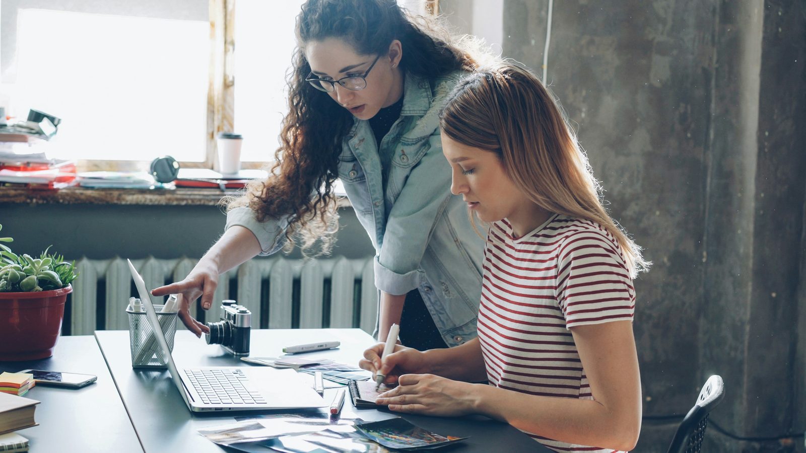 Two colleagues working through documents at a shared desk